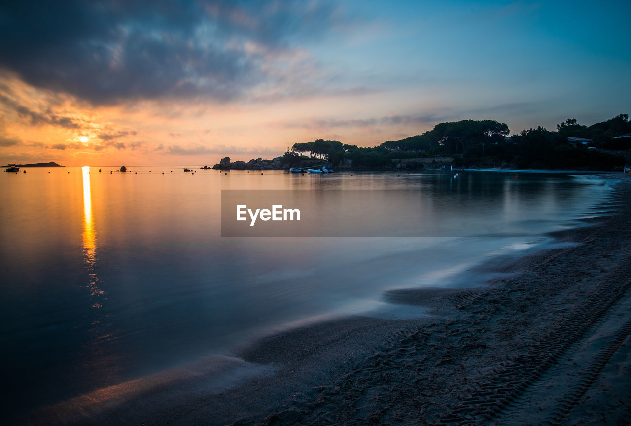 Scenic view of lake against sky at sunset