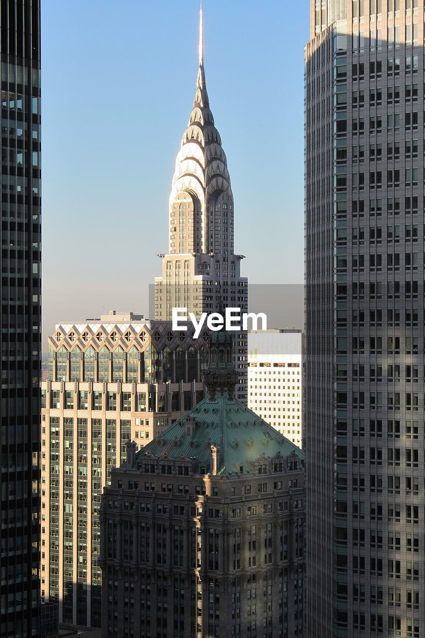 Buildings in city against clear sky