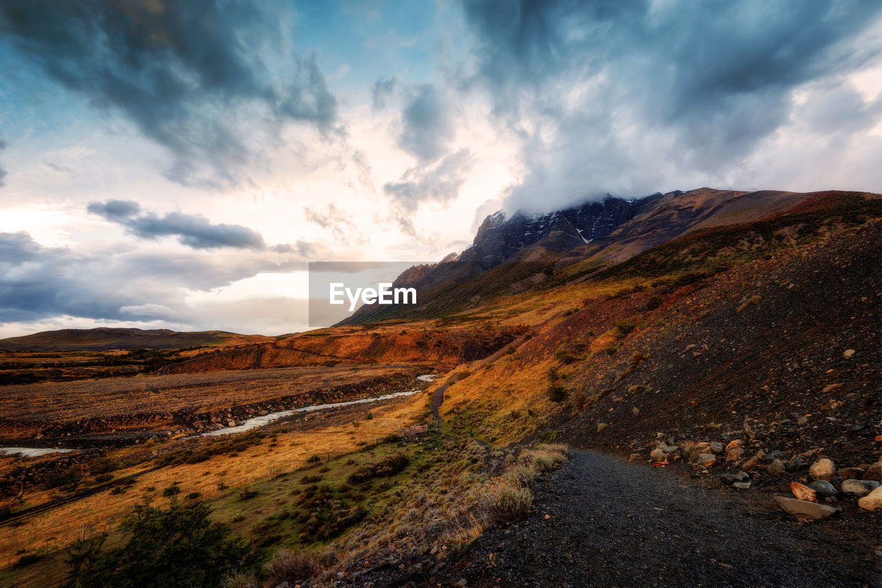 SCENIC VIEW OF ROAD AMIDST MOUNTAINS AGAINST SKY
