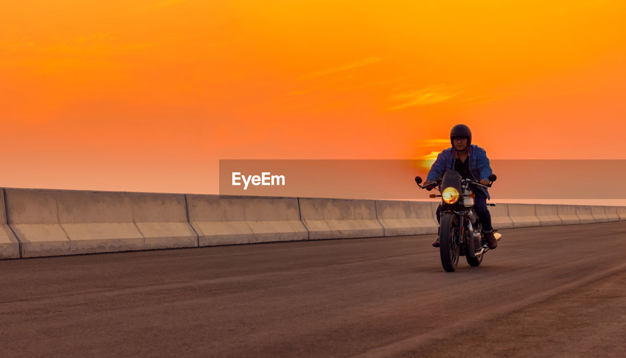 On the route to a summer vacation on a motorcycle, on an asphalt highway, a biker dude wearing .