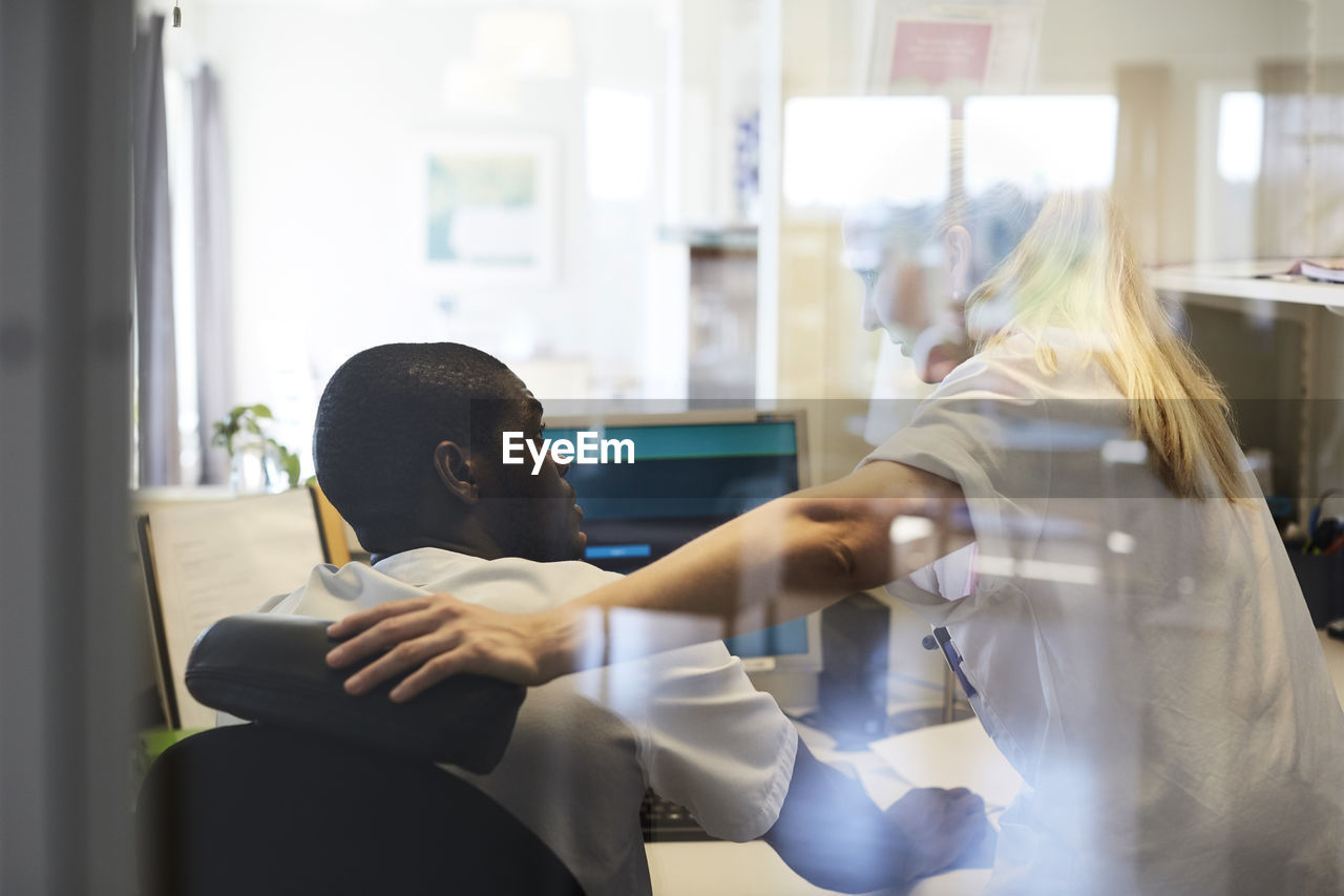 Male and female nurses looking at each other while working in hospital