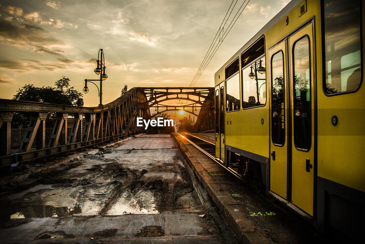 Train on railroad tracks against sky during sunset