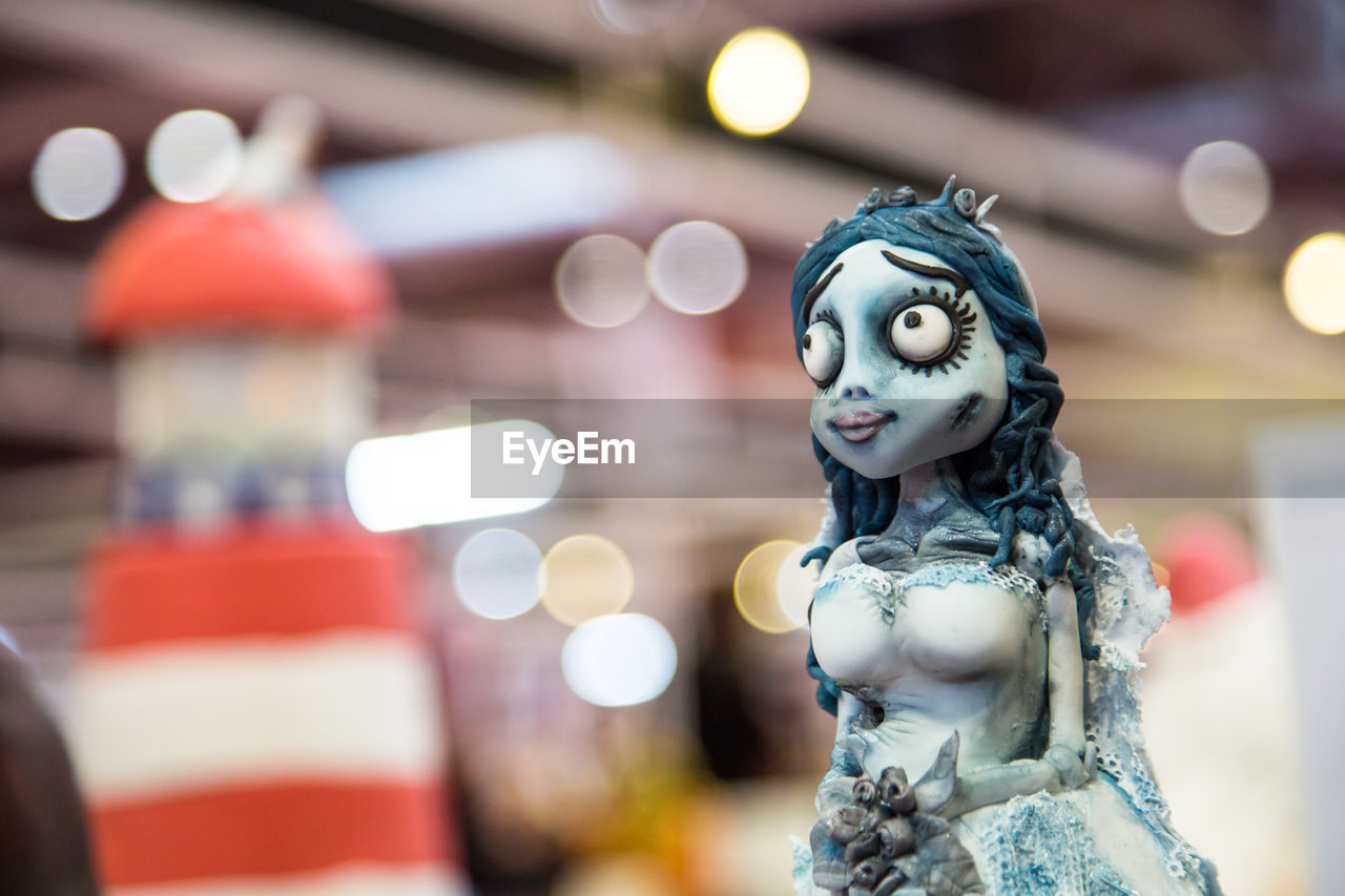 Close-up of fairy figurine against illuminated defocused lights in store