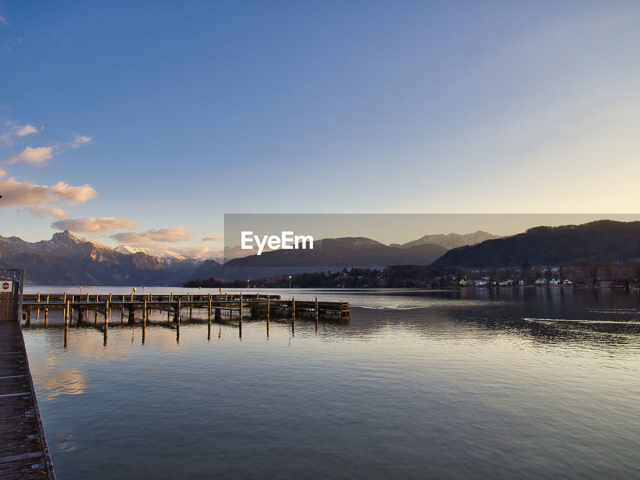 PIER OVER LAKE AGAINST SKY AT SUNSET