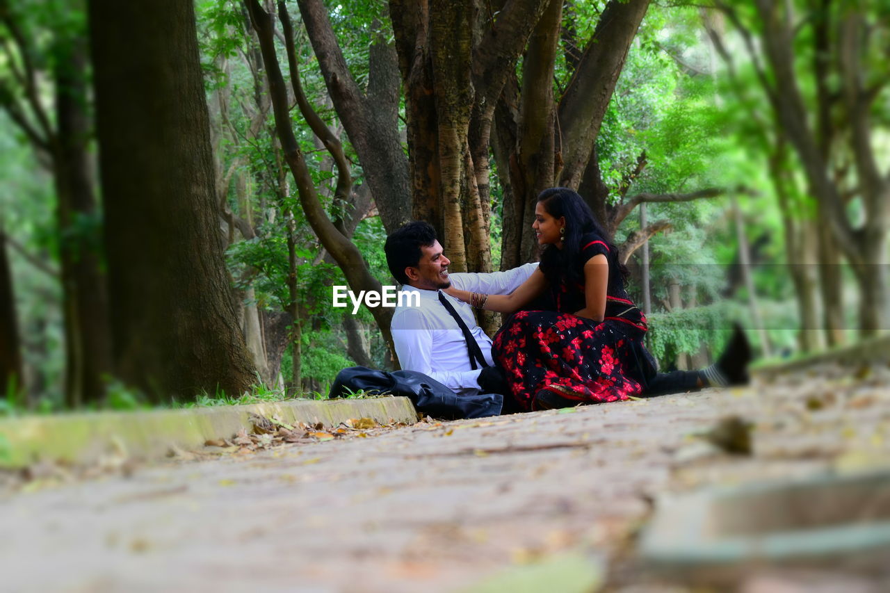 Surface level view of couple sitting at park