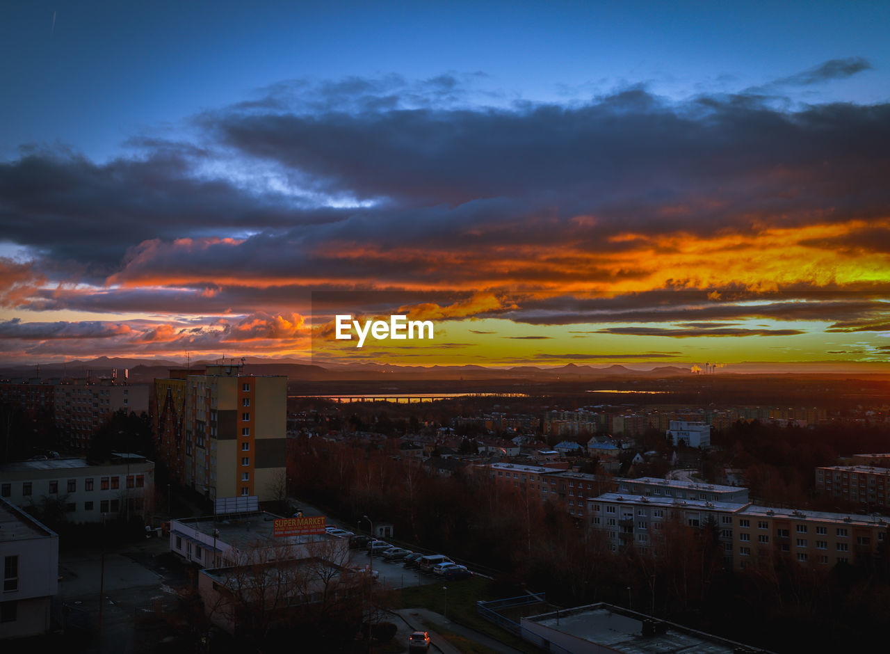 HIGH ANGLE VIEW OF BUILDINGS IN CITY AT SUNSET