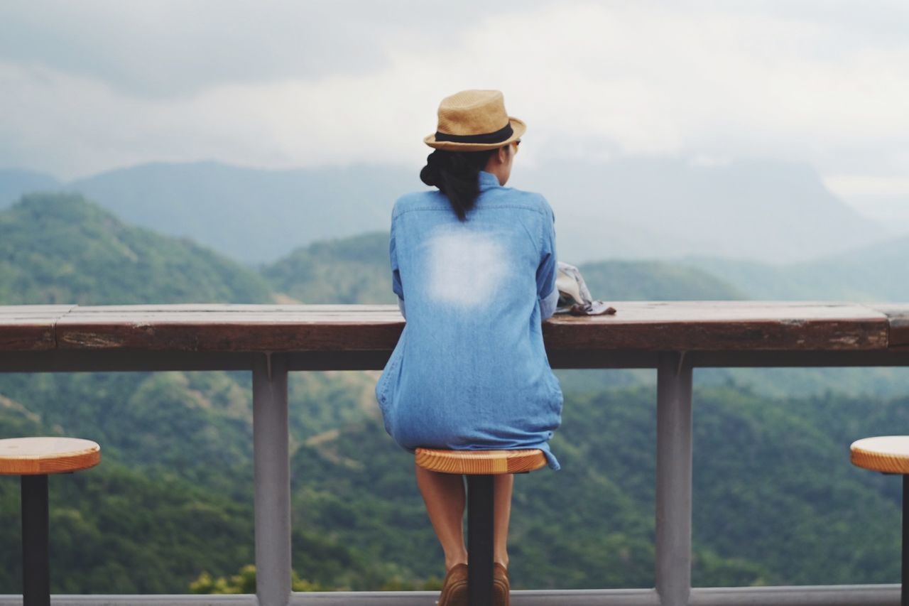 Rear view of woman wearing hat against mountains