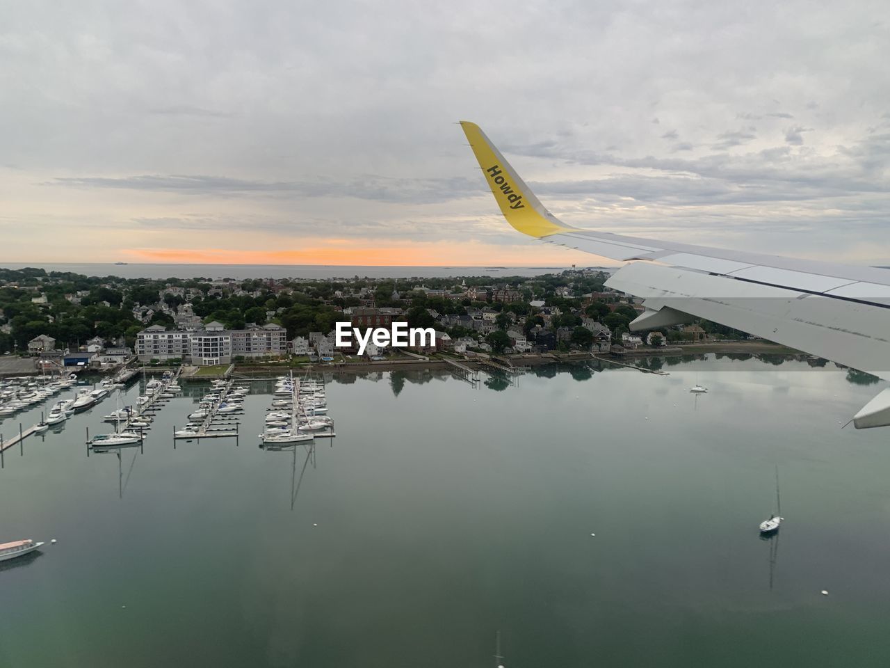 water, transportation, airplane, sky, aircraft, mode of transportation, airliner, vehicle, travel, cloud, nature, aviation, air vehicle, reflection, architecture, environment, flying, no people, air travel, sea, outdoors, travel destinations, aerial view, nautical vessel, wing, city, built structure, day, aircraft wing, takeoff, building exterior, business finance and industry, sunset, narrow-body aircraft, scenics - nature, tourism, beauty in nature