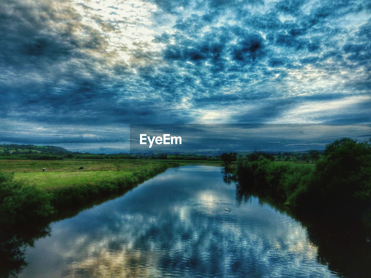 SCENIC VIEW OF LAKE AGAINST CLOUDY SKY