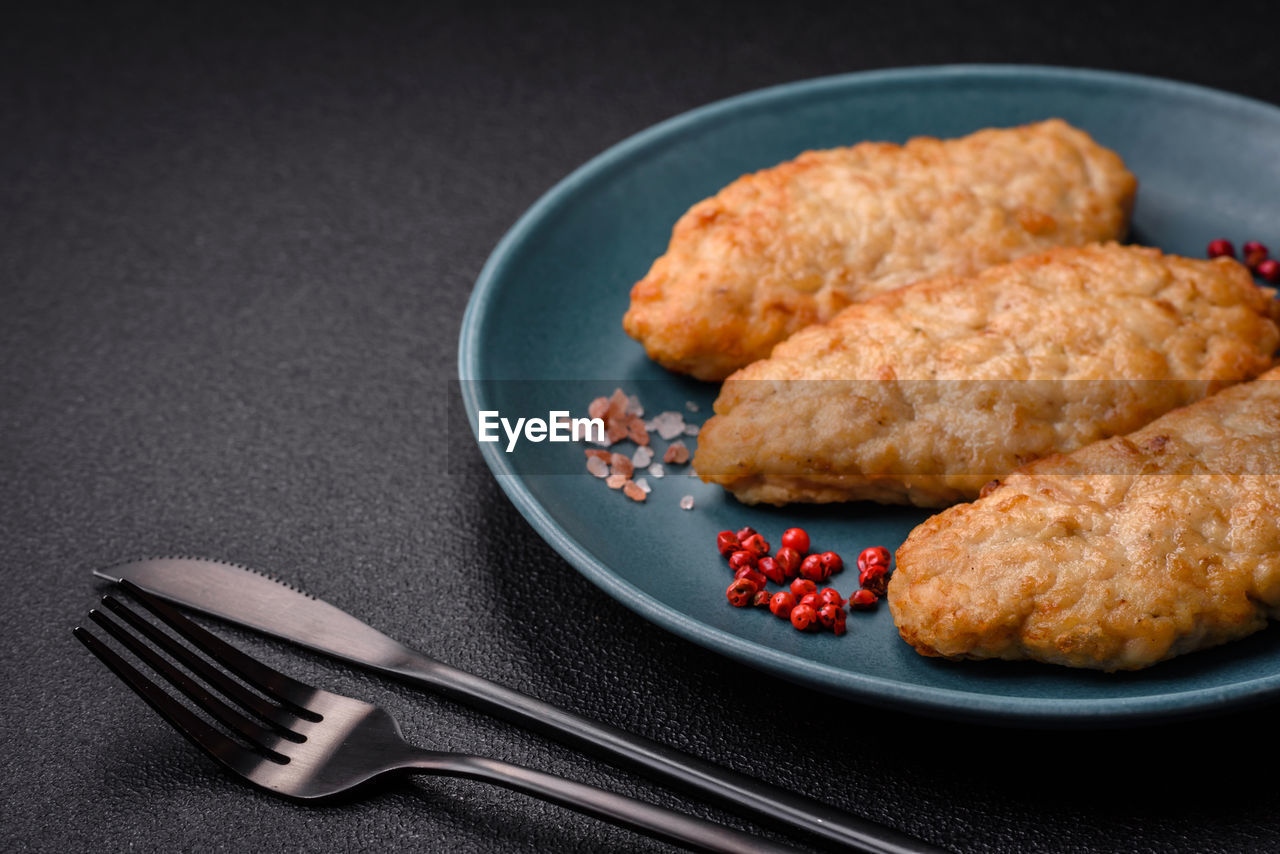 food and drink, food, fried food, plate, meat, studio shot, dish, fried, freshness, no people, fast food, meal, chicken meat, indoors, chicken, black background, healthy eating, produce, fish, fried chicken, fork, chicken fingers, dinner, kitchen utensil, close-up