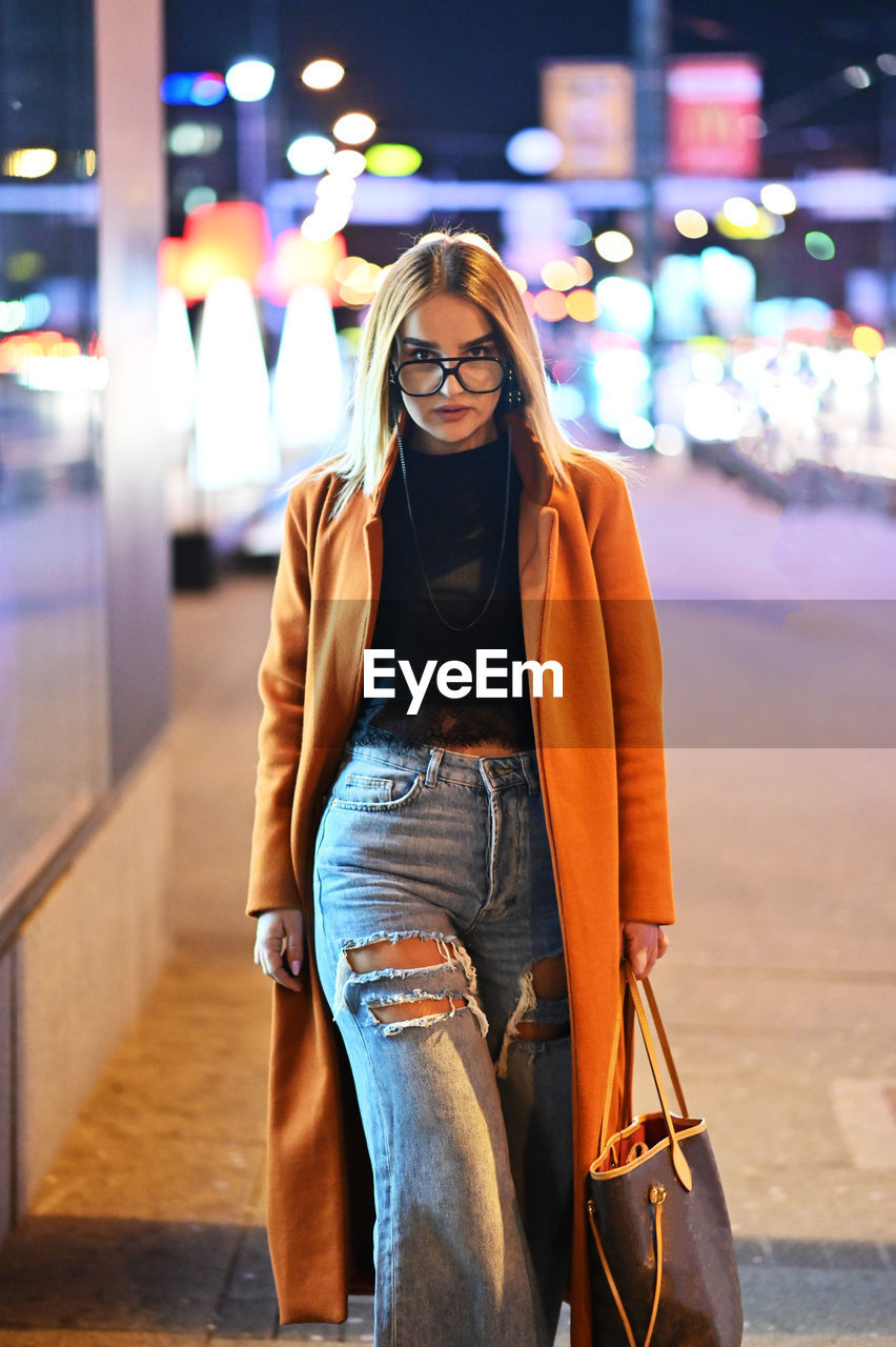 FULL LENGTH PORTRAIT OF YOUNG WOMAN AT BUS