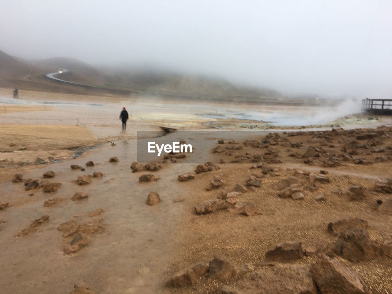 REAR VIEW OF MAN WALKING ON BEACH