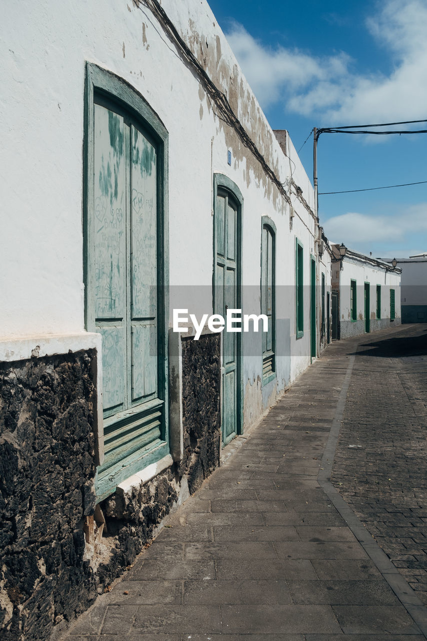 architecture, urban area, built structure, sky, building exterior, road, street, building, blue, cloud, no people, wall, house, nature, window, entrance, door, day, city, transport, outdoors, old, facade, transportation, residential area, abandoned, town