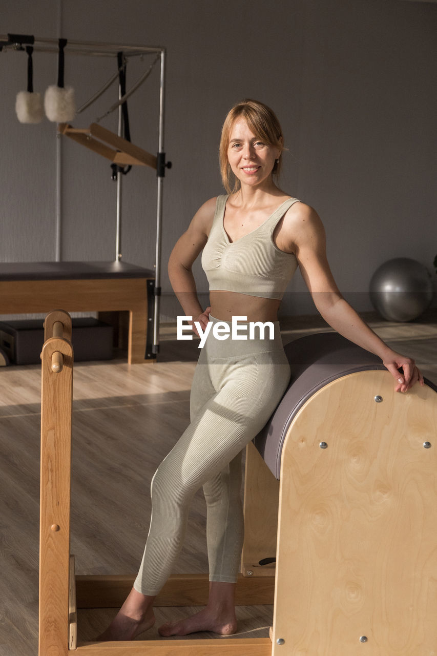 portrait of young woman standing on chair