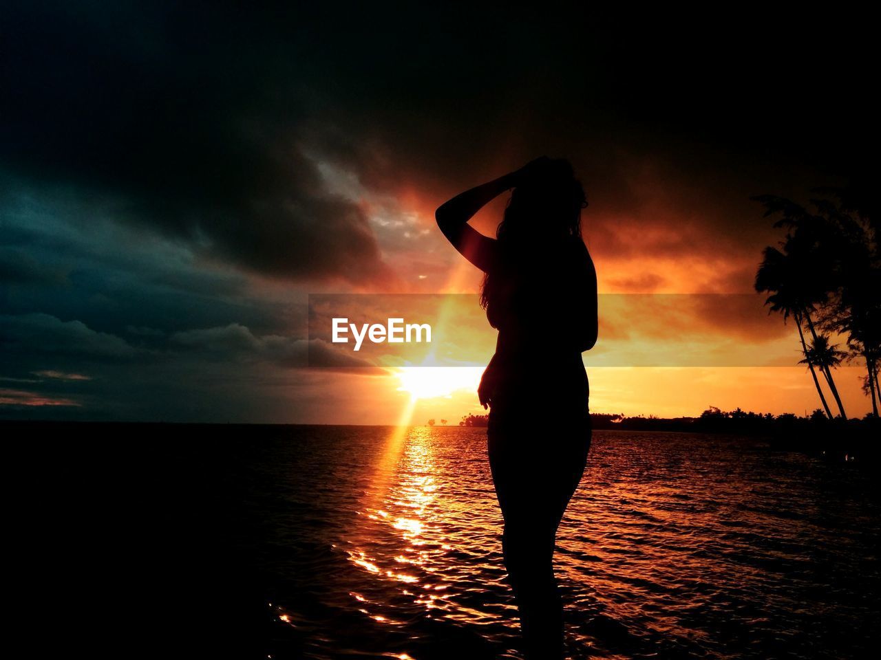 SILHOUETTE WOMAN STANDING ON BEACH DURING SUNSET