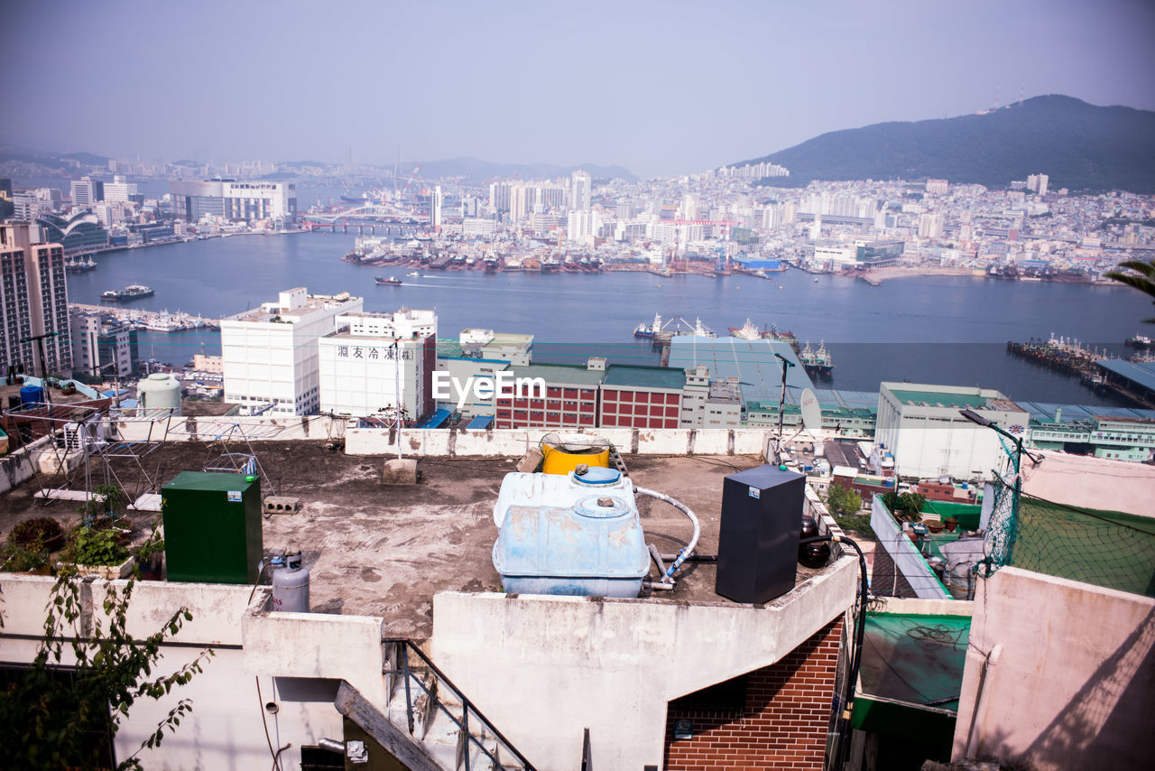 High angle view of cityscape at waterfront during sunny day