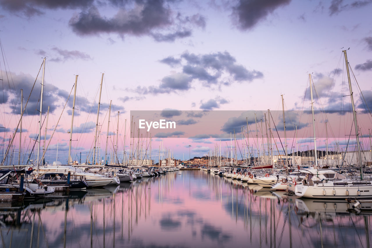 SAILBOATS MOORED IN HARBOR