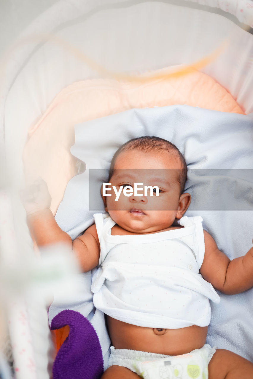 high angle view of cute baby boy sleeping on bed