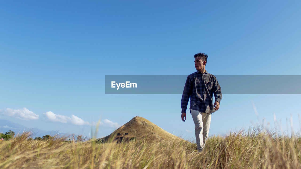 Full length of man standing on field against sky