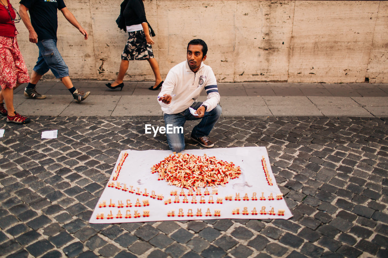 HIGH ANGLE VIEW OF MAN WITH UMBRELLA ON STREET