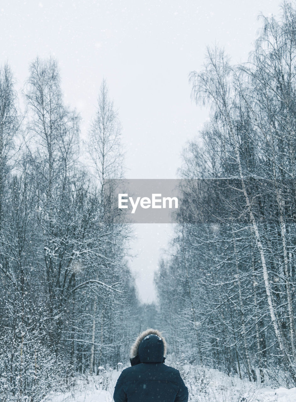 Man on snow covered landscape against sky