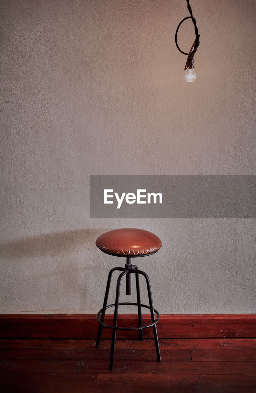 A stool and a bare light bulb