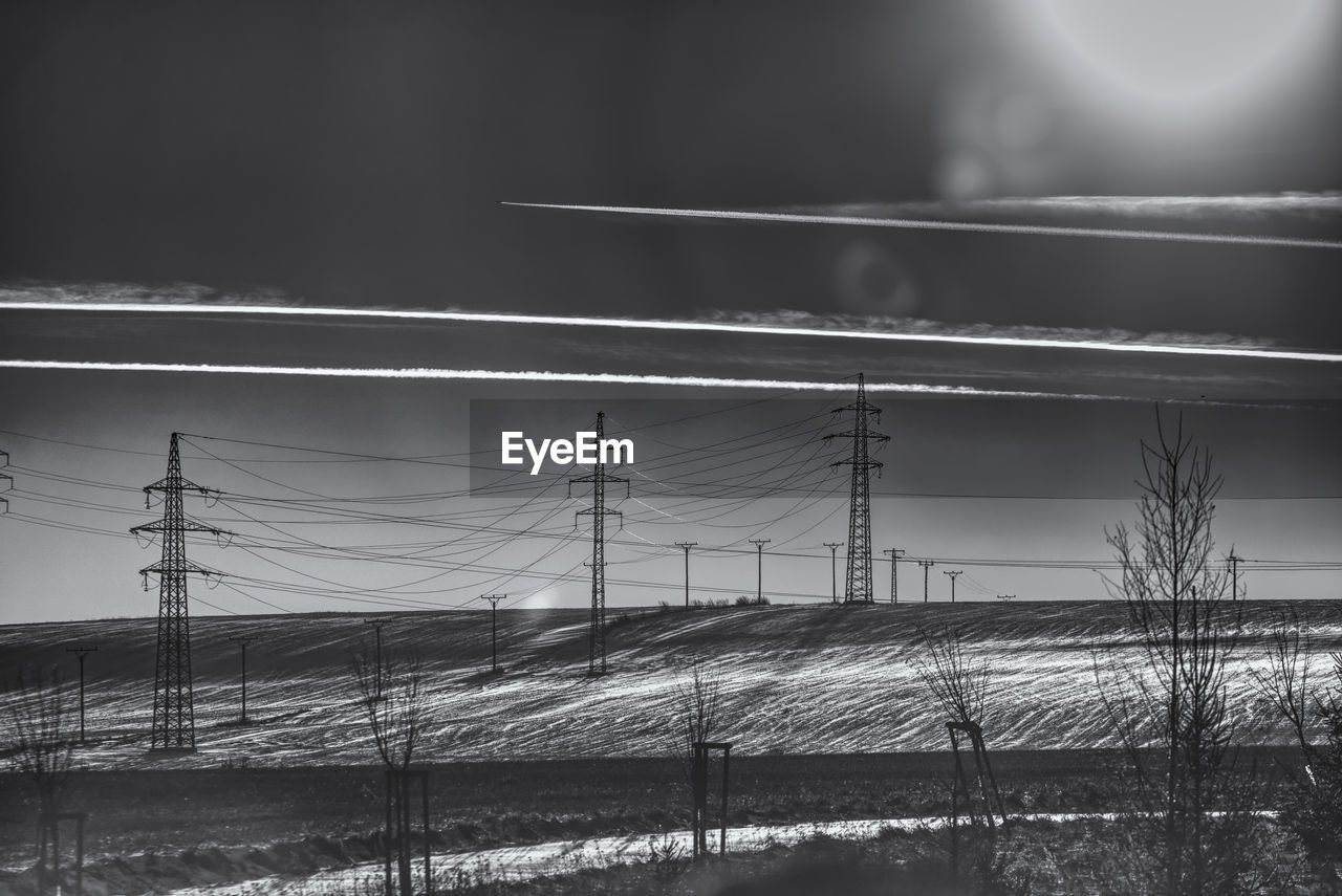 Electricity pylon on field against sky 