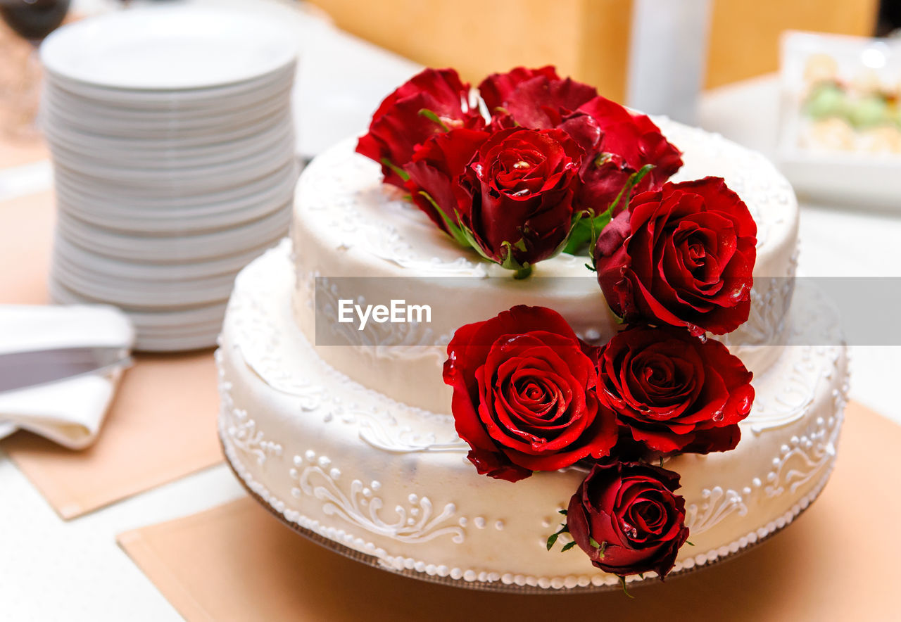 Close-up of roses over cake on table