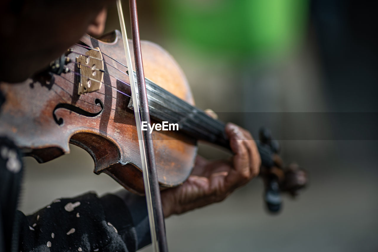 Midsection of man playing violin