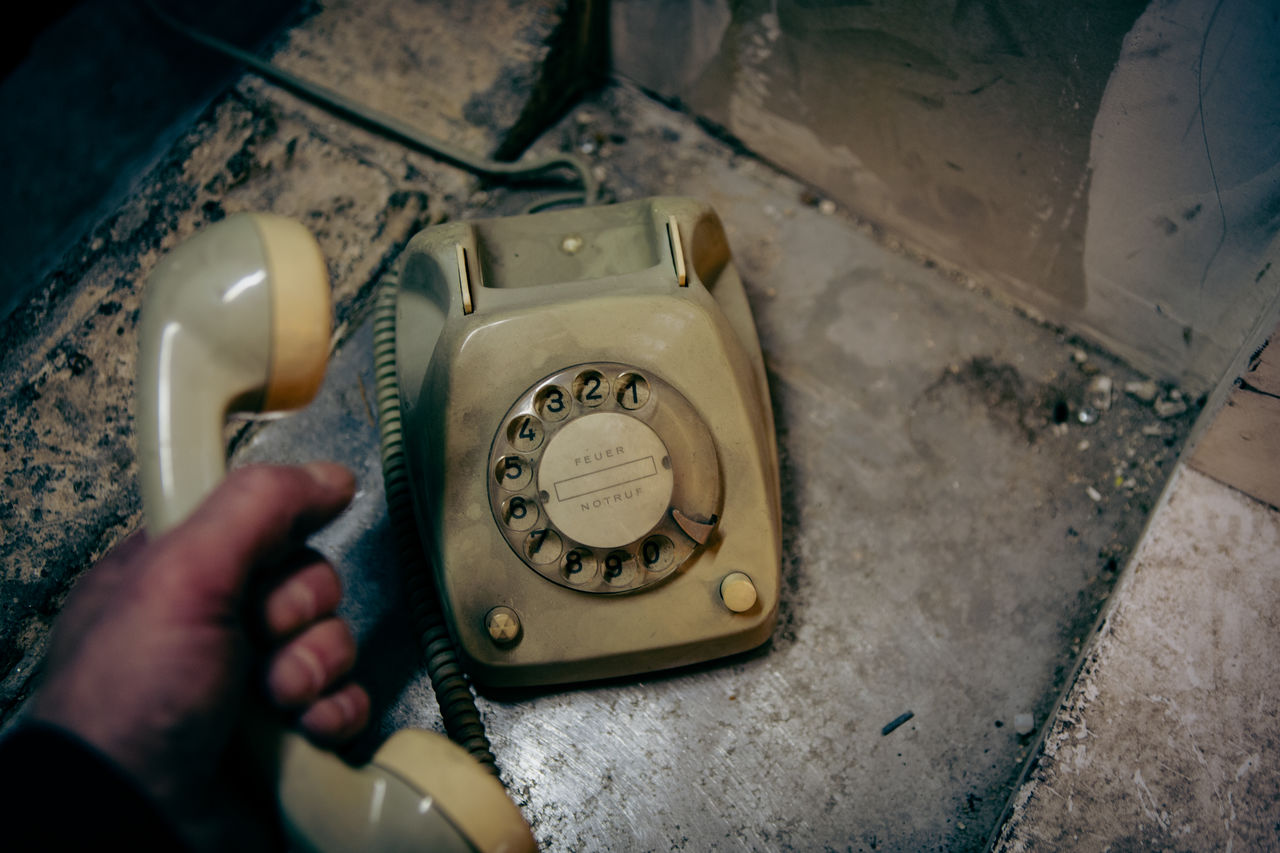 hand, one person, blue, technology, indoors, retro styled, telephone, holding, corded phone, white, communication, adult, light, high angle view, black, close-up, history, old, the past