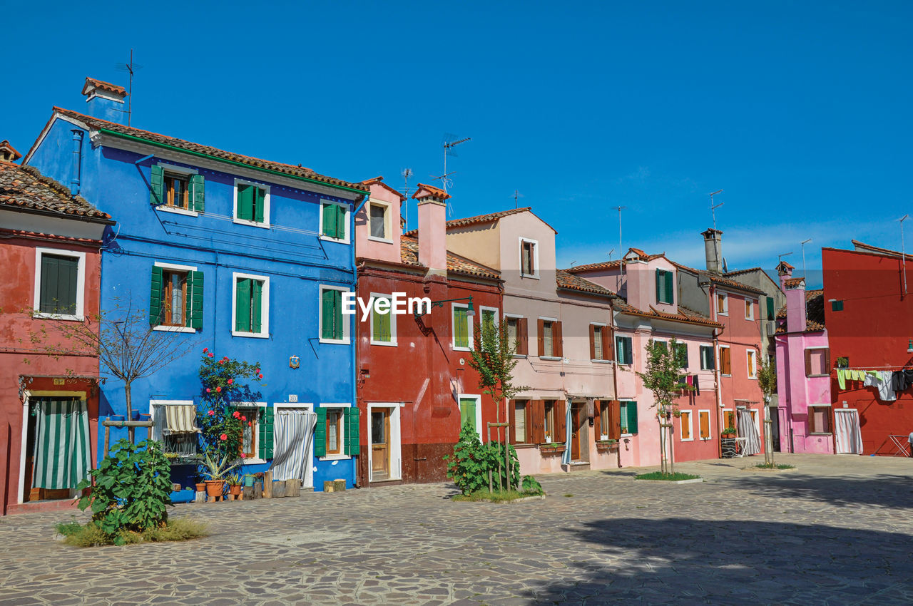 View of colorful houses on sunny day in burano, a gracious little town full of canals in italy.