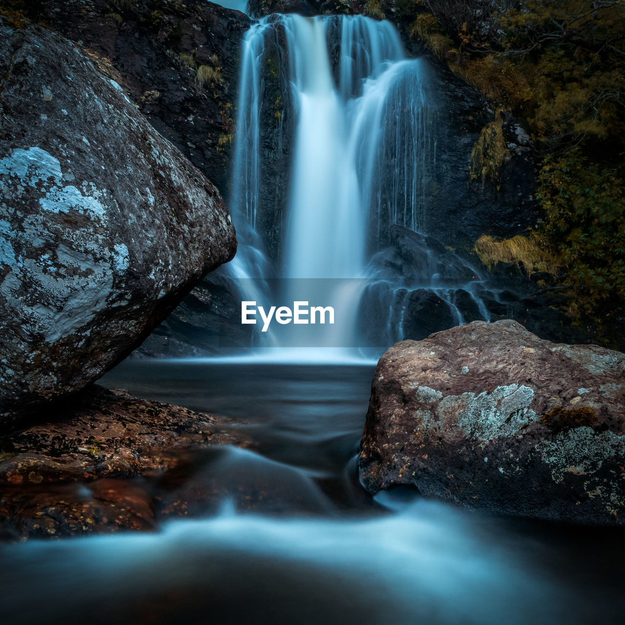 SCENIC VIEW OF WATERFALL IN ROCKS