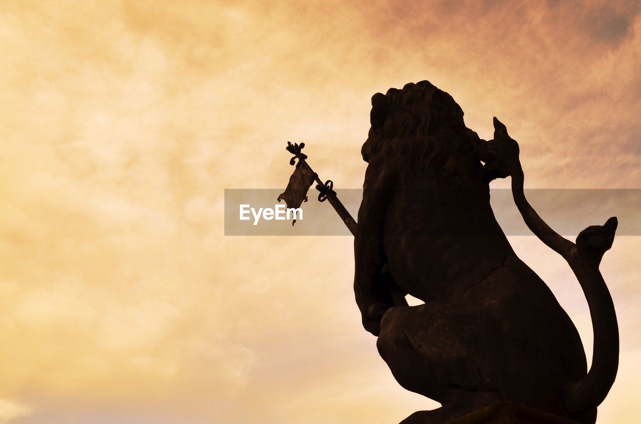 SILHOUETTE OF PERSON RIDING MOTORCYCLE ON MOUNTAIN