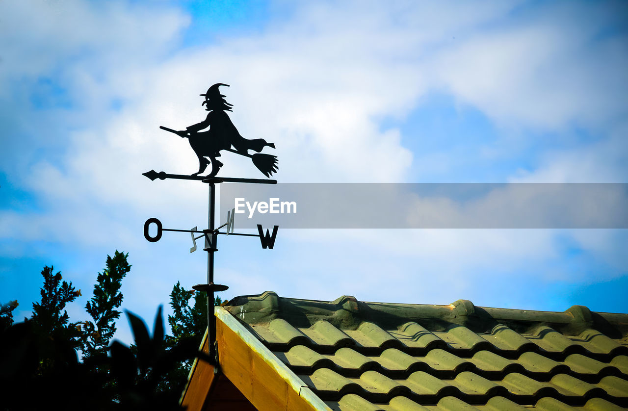 LOW ANGLE VIEW OF WEATHER VANE ON ROOF