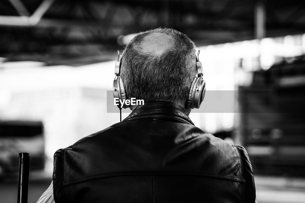 Rear view of man wearing headphone