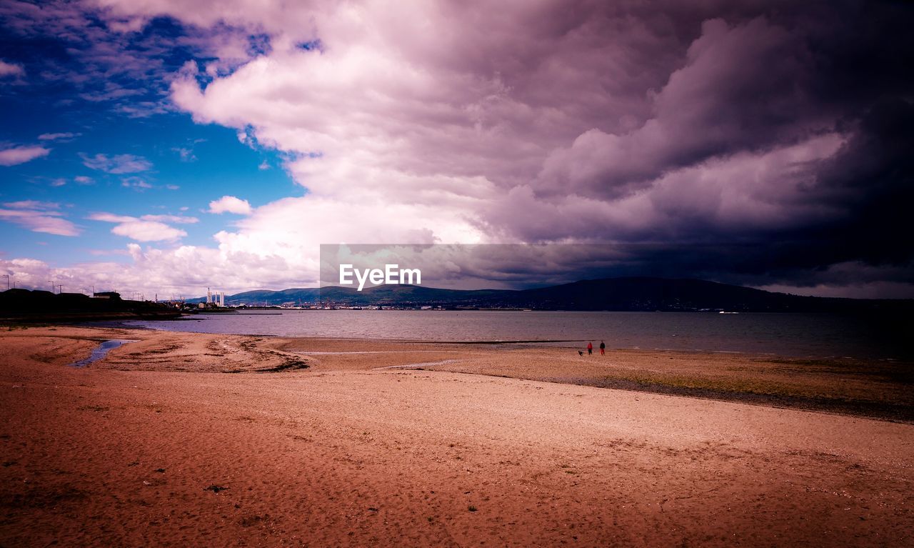 VIEW OF BEACH AGAINST CLOUDY SKY