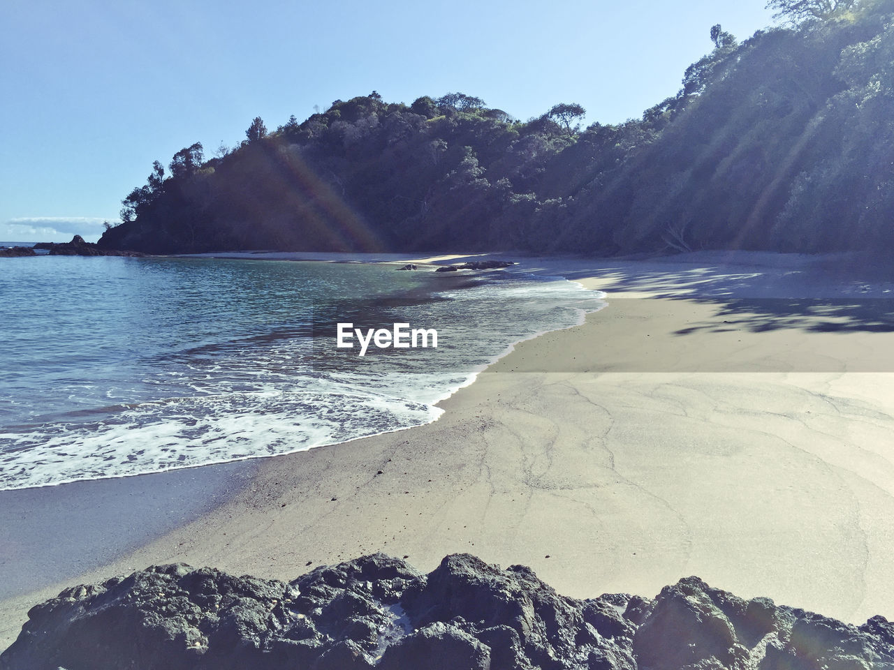 View of calm beach against mountain range