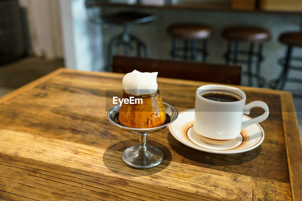 CLOSE-UP OF COFFEE CUP AND GLASS ON TABLE