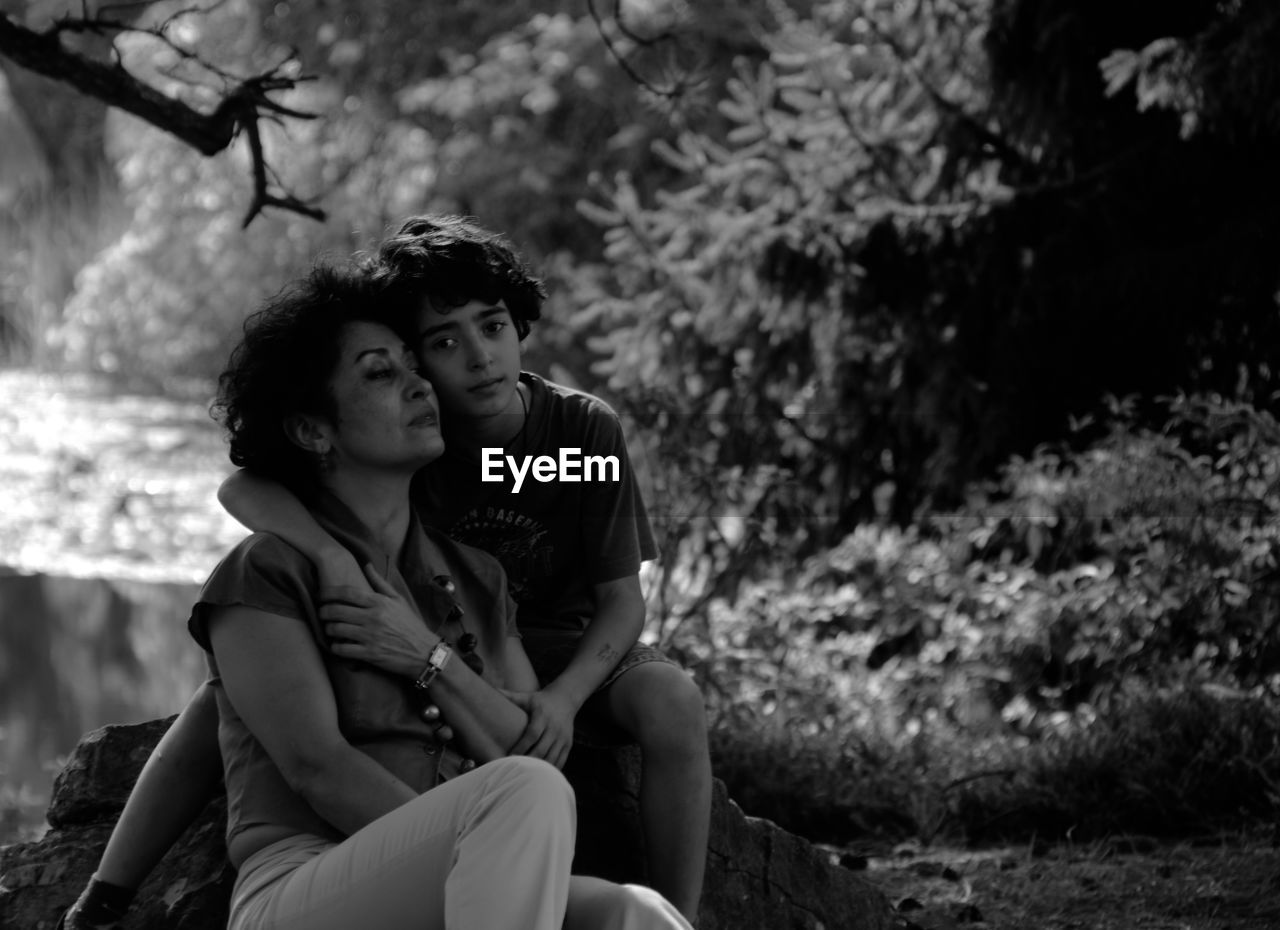 Portrait of mother and son sitting in forest