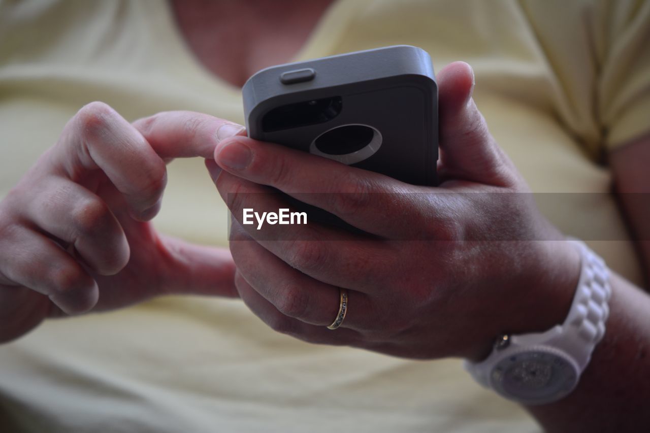 CLOSE-UP OF HAND HOLDING SMART PHONE