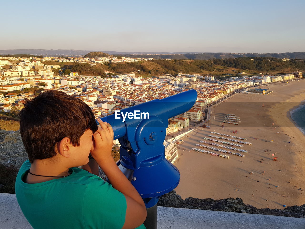 Rear view of boy and cityscape against sky