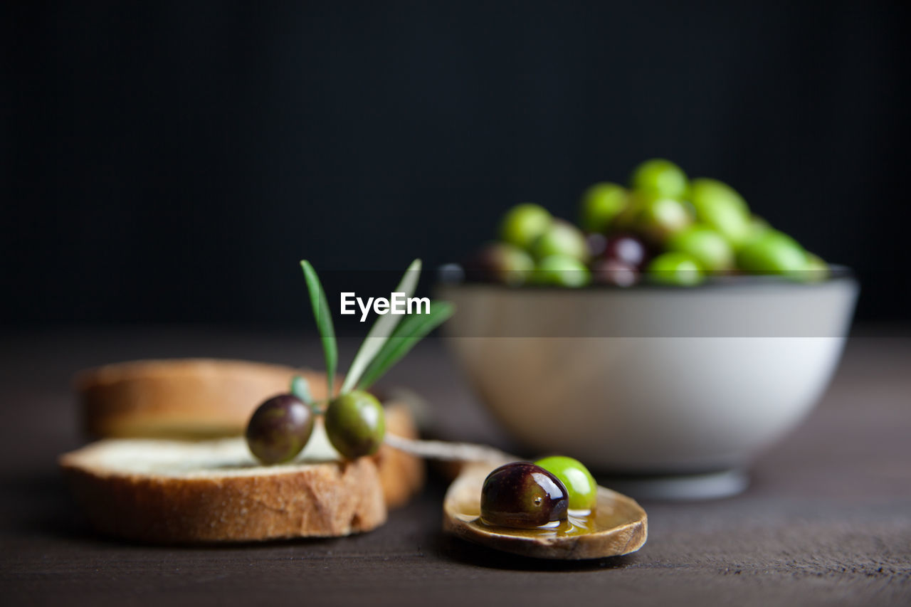 High angle view of green olives and bread on table
