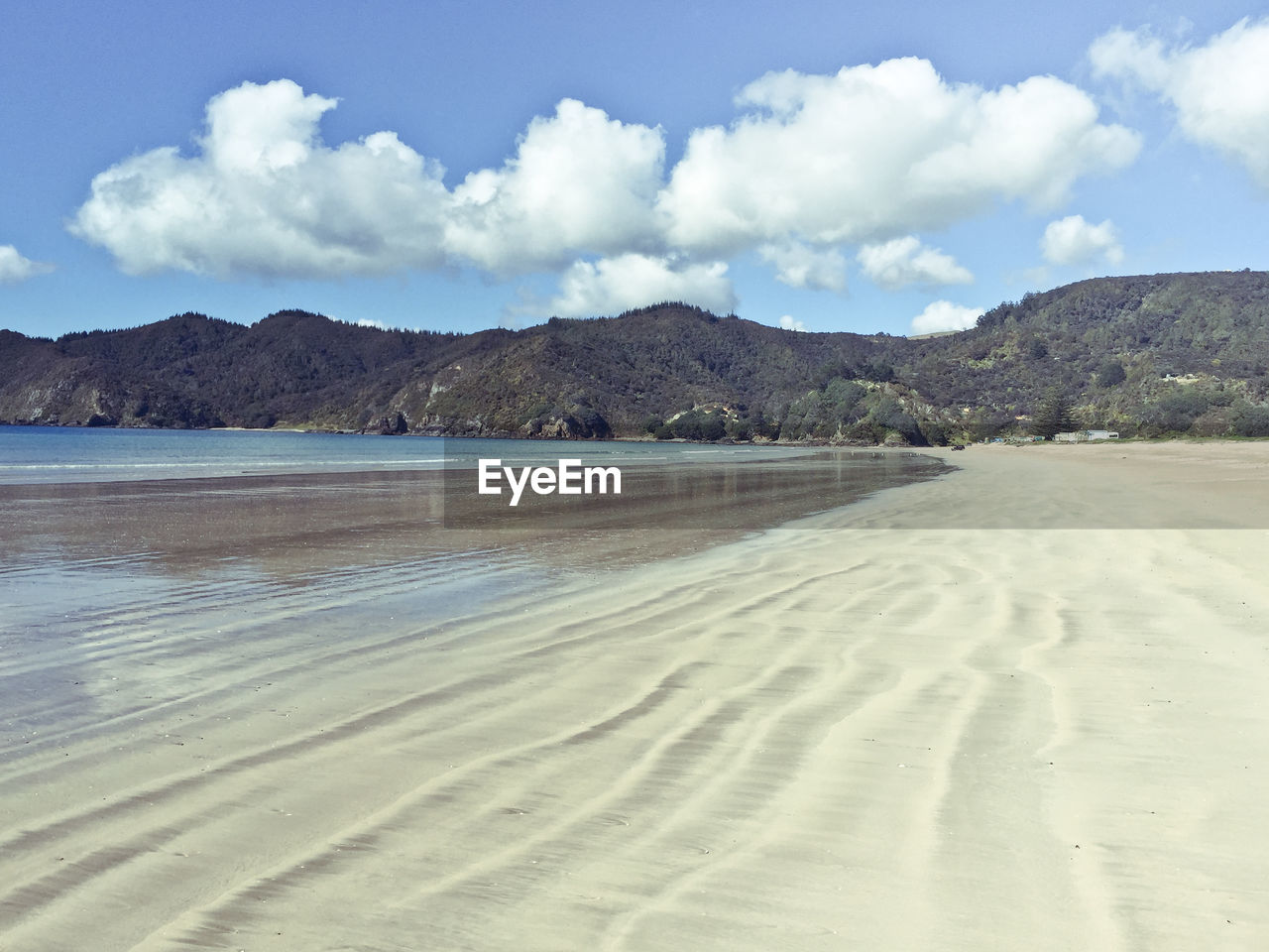 VIEW OF BEACH AGAINST CLOUDY SKY