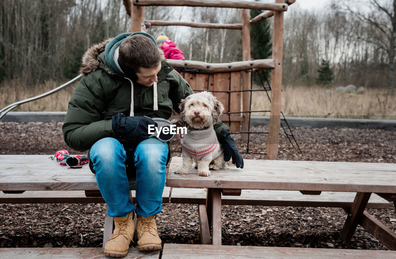 Man sat with his dog on a park bench outside