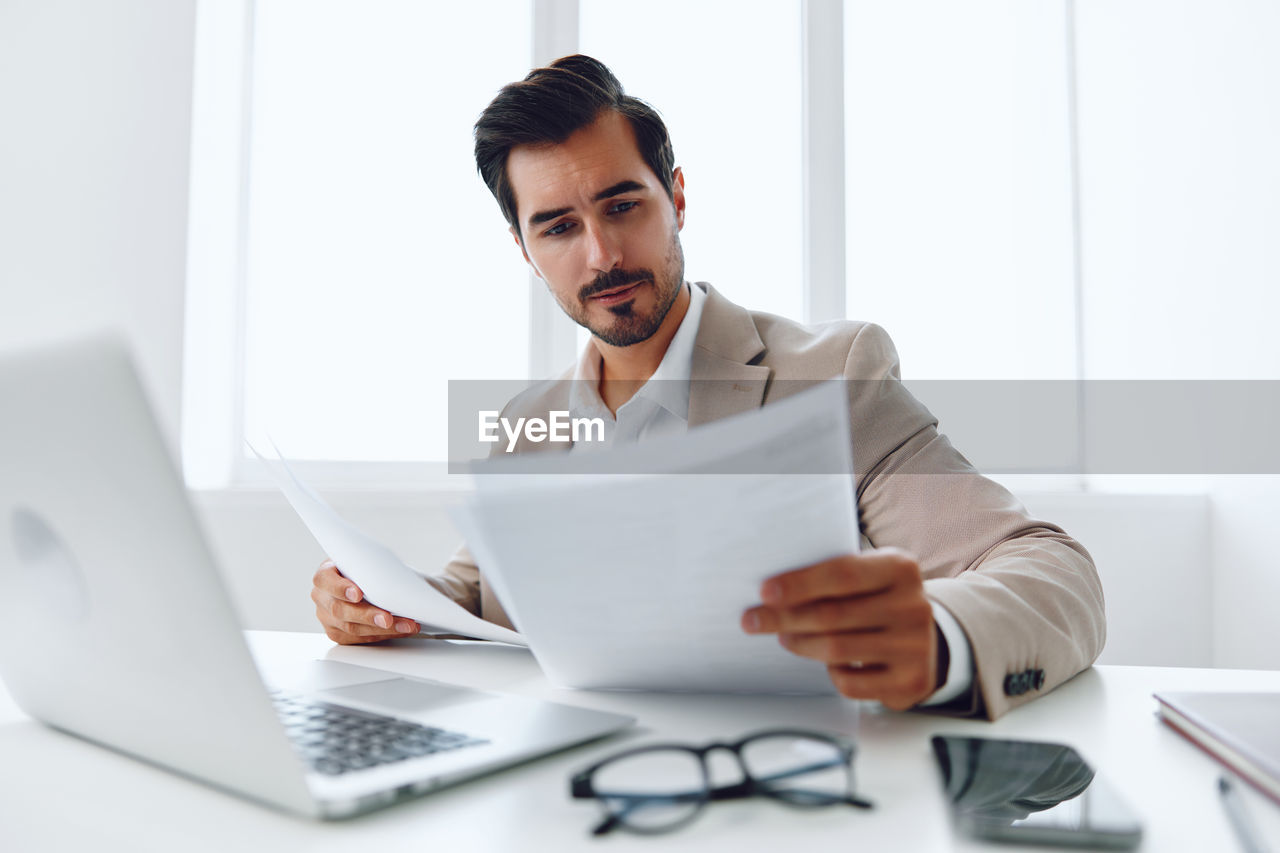 portrait of young man using laptop at office