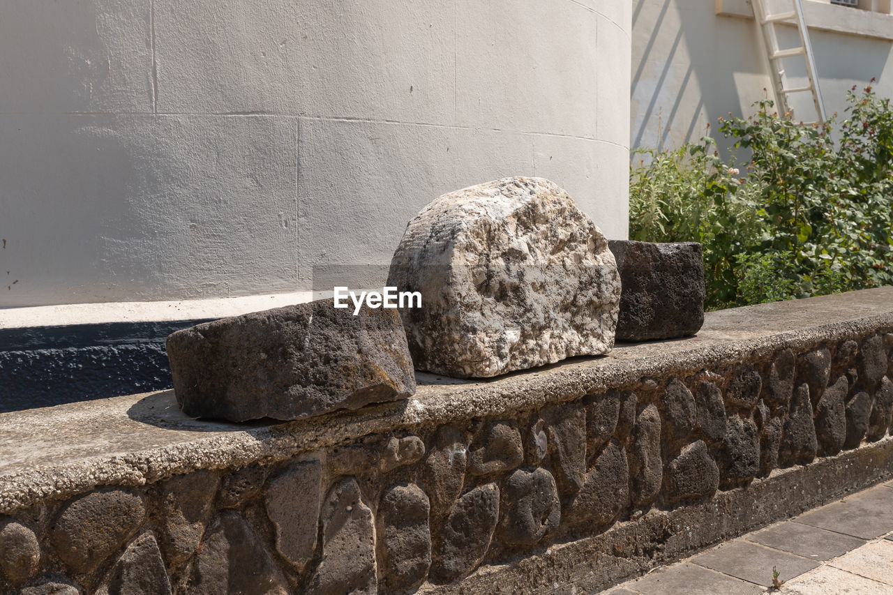 CLOSE-UP OF STONE WALL WITH BUILDING