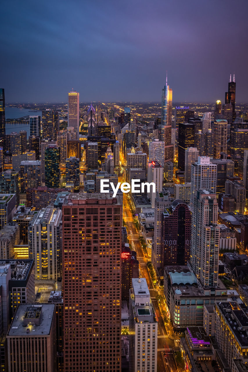 Illuminated cityscape against sky at night