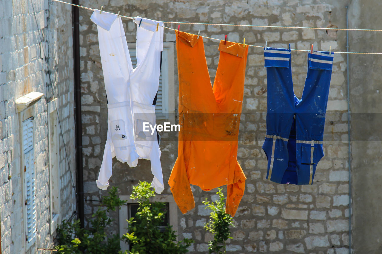 CLOSE-UP OF CLOTHES DRYING AGAINST WALL