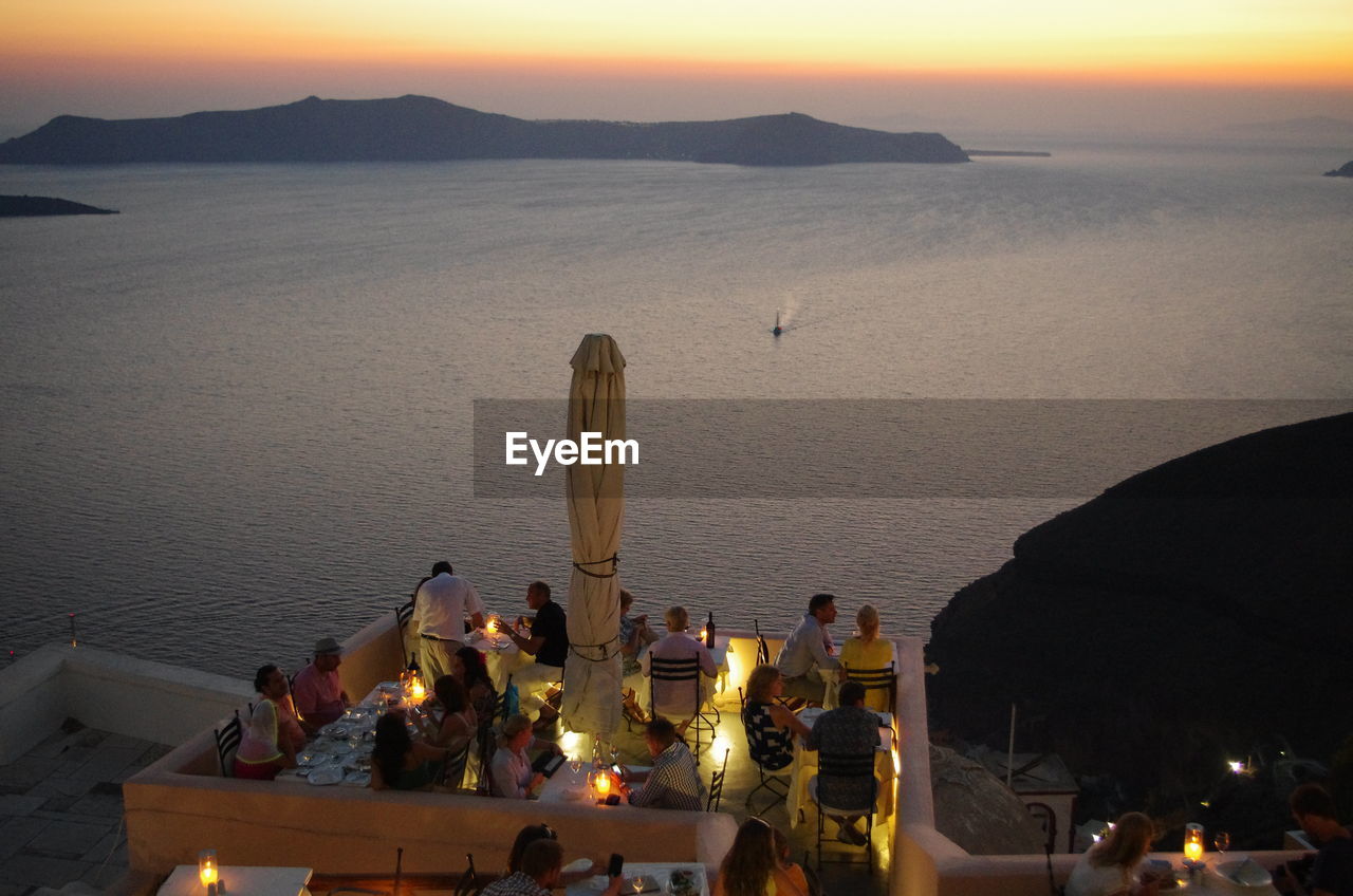 HIGH ANGLE VIEW OF PEOPLE BY SEA AGAINST SKY