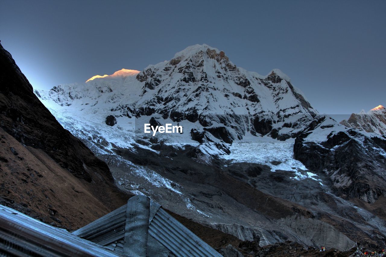 Scenic view of snowcapped mountains against clear sky